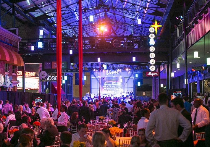 Well-dressed guests enjoy an open-air atmosphere under a canopy roof as a band plays on stage at the Power Plant Live! Alley.